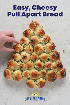 a person holding a piece of bread in the shape of a christmas tree