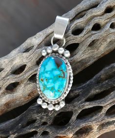 This Navajo pendant is handcrafted in Sterling Silver featuring a breathtaking Kingman Turquoise stone. This specific stone is a bright blue shade with a webbed matrix. This is the perfect gift to yourself or someone you love! Measures: 7/8" x 3/8" with the bale Includes 18" Sterling Silver Chain Weight: 2 grams Stamped: Sterling Signed: AT (Anabelle Tom) Kingman Turquoise, American Jewelry, Turquoise Pendant, Native American Jewelry, Turquoise Stone, Bright Blue, Things To Buy, Sterling Silver Chains, Native American