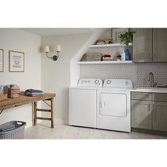 a white washer and dryer sitting next to each other in a laundry room