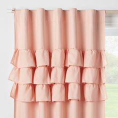 a pink curtain with ruffled edges hanging in front of a window