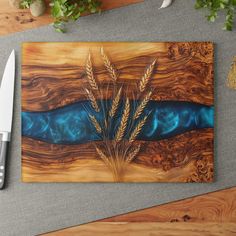 a knife sits next to a cutting board with an image of wheat and blue liquid on it