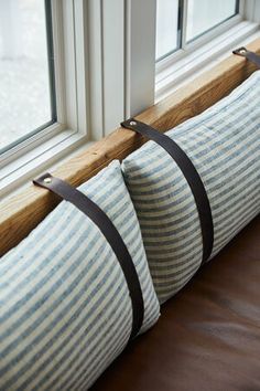 two blue and white striped pillows on a window sill