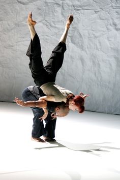 two people doing tricks in the air with their hands on each other's hips