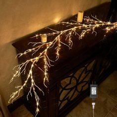 some lights that are on top of a wooden table in front of a wall with candles