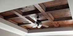 a bedroom with a ceiling fan and wood paneled ceilings in the middle of it