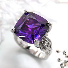 This beautiful Simulated Amethyst Ring, Sterling Silver Statement Ring for Women, Cushion Cut 10.5 Carat Vintage Cocktail Ring, Edwardian Engagement Ring by DoubleAccent is meticulously crafted in gleaming and durable Sterling Silver. Our stones are the highest quality diamond simulant that are polished, finely cut, loupe clean, and have an exactly similar appearance and as beautiful as to naturally occurring diamonds. All cubic zirconia stone weights are approximate and listed as diamond equiva Formal Purple Sapphire Ring With Gemstone Accents, Formal Amethyst Rings With Vs Clarity, Formal Amethyst Ring With Vs Clarity, Elegant Purple Crystal Ring With Prong Setting, Purple Ring With Gemstone Accents For Formal Occasions, Fine Jewelry Amethyst Ring With Vs Clarity, Formal Amethyst Birthstone Ring With Gemstone Accents, Elegant Purple Crystal Ring With Accent Stones, Elegant Purple Amethyst Ring For Gift