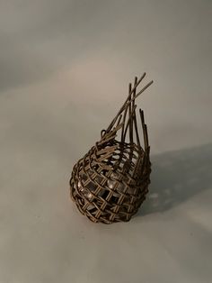 a basket made out of sticks on a white surface