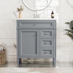 a bathroom vanity with marble top and grey cabinet, white tile flooring and large round mirror on the wall