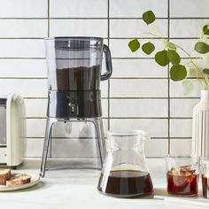 a blender with liquid in it sitting on a counter next to some toasters