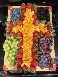 a cross made out of fruits and vegetables on a cutting board in front of an oven