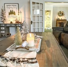 a living room filled with furniture and a christmas tree on top of a coffee table