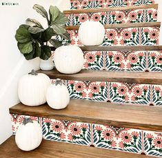 some white pumpkins are sitting on the steps