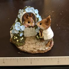 two figurines sitting on top of a wooden table