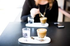 a woman sitting at a table with a cup of coffee in front of her and a sign that says, there are simple small things that we can do that can be meaning