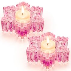 two pink candles are sitting next to each other