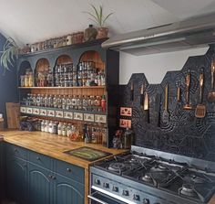 a kitchen with an oven, stove and shelves filled with cooking utensils on the wall