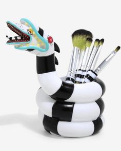 a black and white snake cup with brushes in it