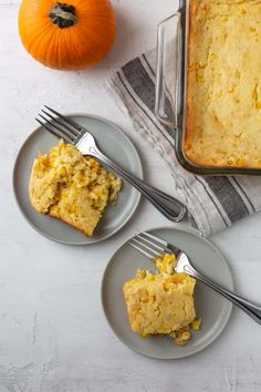 two plates with food on them next to a fork and a pumpkin in the background