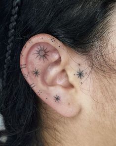 a woman's ear with small stars on it