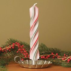 two candles sitting on top of a metal bowl