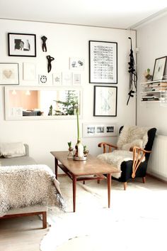 a living room filled with furniture and pictures on the wall