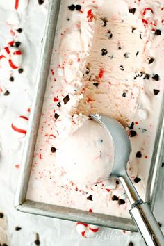 a scoop of ice cream with sprinkles in a metal container on a table