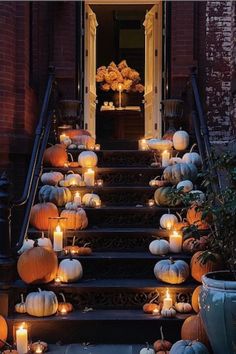 a set of stairs with lit pumpkins and candles on the steps leading up to it