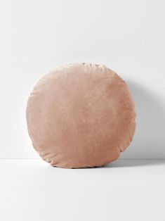 a round pillow sitting on top of a white floor