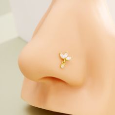 This 14k solid gold lotus earring nose stud embodies a fusion of elegance and modern chic. Crafted in pure gold, it features a delicate lotus design embellished with sparkling, clear cubic zirconia, exuding a refined and contemporary charm. This stud earring, with its sleek and minimalist aesthetics, adds a touch of sophistication to any style, serving as a symbol of beauty, purity, and contemporary fashion sensibility. Lotus Nose Stud, Flower Nose Stud, Titanium Belly Button Rings, Ring Day, Conch Hoop, Helix Earring, Lotus Earrings, Gold Lotus, Dangle Belly Rings