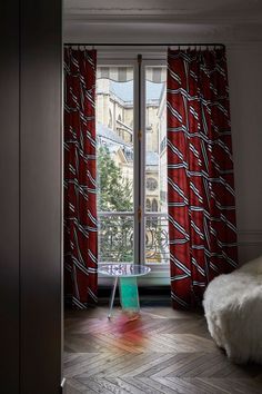 an open door leading to a bedroom with red curtains