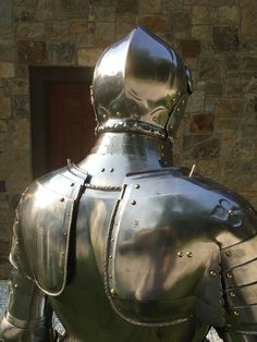 a large metal armor is standing in front of a building