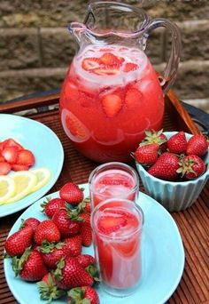 a pitcher of water with strawberries next to it on a tray