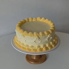 a yellow and white cake sitting on top of a table