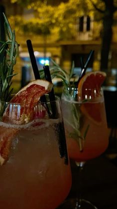 two glasses filled with drinks sitting on top of a table