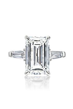 an emerald - cut diamond ring with baguets on the shoulders and side stones