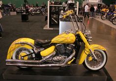 a yellow motorcycle is on display in a showroom