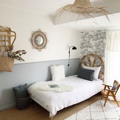 a bed room with a neatly made bed next to a chair and wall hangings