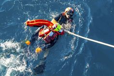 a man is in the water wearing a life jacket and holding on to a rope