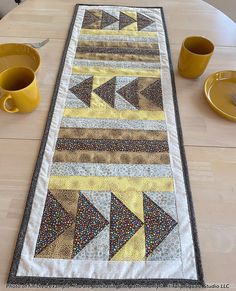 a table runner with yellow cups on it