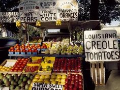 a fruit stand with lots of fruits and vegetables for sale on it's sides