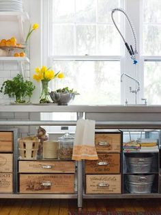 an image of a kitchen with wooden crates on the counter and flowers in vases