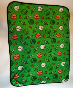 an oven mitt covered in green fabric with red and white objects on it's side