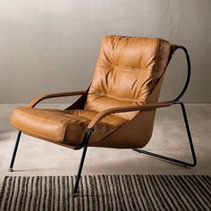 a brown leather chair sitting on top of a rug