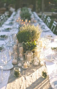 the table is set with candles and greenery