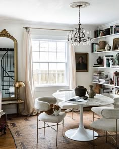 a living room filled with furniture and a cat sitting on top of a white table