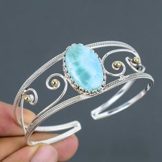 Note: Due to the natural formation of this gemstone. Slight variation in design and color are to be expected. Larimar Cuff Bracelet 925 Sterling Silver Bracelet 18K Gold Plated Adjustable Bangle Handmade Unique Jewelry Gemstone Bangle Engagement Gift SKU  : VC-24 Handmade Cuff Bracelet Gemstone : Larimar  Stone Shape : Oval Metal Purity : 925 Sterling Silver Cuff Bracelet Size : Adjustable Larimar is said to enlighten and heal in a physical, emotional, mental and spiritual way. It stimulates the Cuff Bracelets Handmade, Gemstone Bangle, Handmade Bangles, Sterling Silver Jewelry Handmade, Adjustable Bangle, Sterling Silver Cuff Bracelet, Silver Gemstone Jewelry, Sterling Silver Cuff, Bracelet Sizes