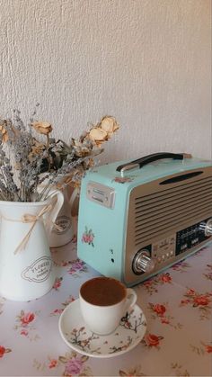 an old fashioned radio sitting on top of a table next to a cup and saucer