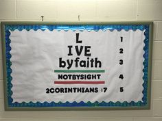 a bulletin board with the words live by faith and not by sight in front of a white brick wall