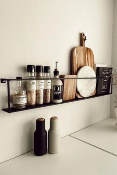 a shelf filled with spices and condiments on top of a white countertop