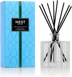 a blue box next to an open reed diffuser with black and white sticks in it